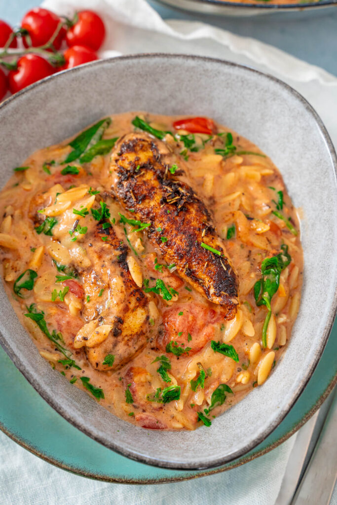 Orzo Pfanne mit Hähnchen und Spinat in der Schüssel servieren